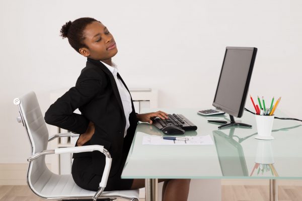 Businesswoman Suffering From Backache While Working In Office